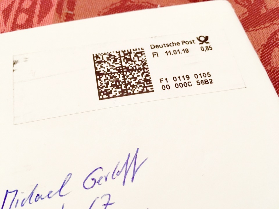 Teil eines Briefumschlags mit Briefmarke und handgeschriebener Adresse