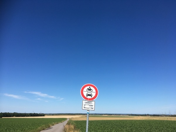 Ein Verkehrszeichen, das die Durchfahrt für PKW und Motorräder verbietet, steht an einem Feldweg
